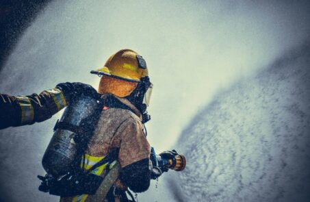 Pompier éteignant un incendie en portant un équipement de protection